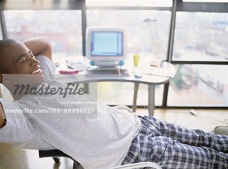 Man Sitting in Chair, Relaxing Near Computer