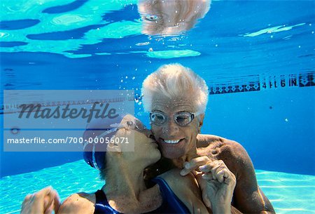 Mature femme embrasse un homme d'âge mûr sous-marine dans la piscine