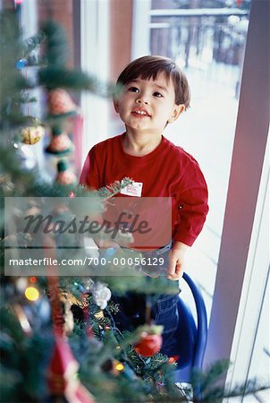 Garçon debout près d'arbre de Noël