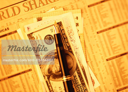 Money and Pen on Stock Pages Money and Pen on Stock Pages