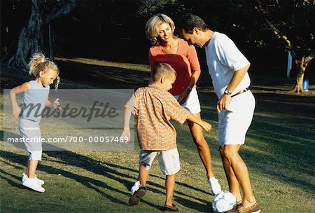 Family Playing with Soccer Ball In Park