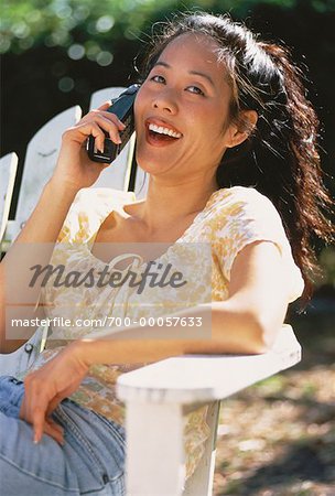 Porträt der Frau im Stuhl mit Telefon im freien