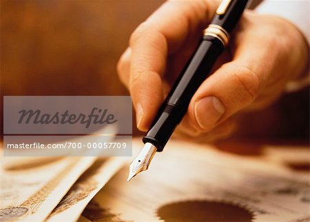 Close-Up of Hand Holding Pen Signing Certificates