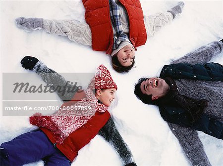 Obenliegende Ansicht der Familie im Schnee liegen, so dass Schnee-Engel