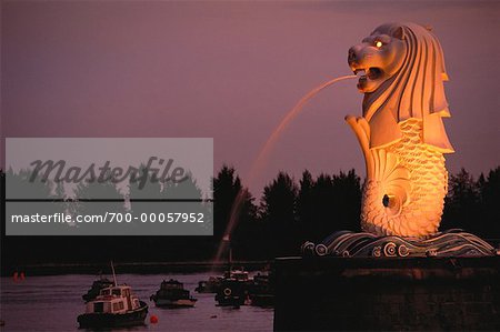 Statue du Merlion jaillissant de l'eau au crépuscule, Singapour