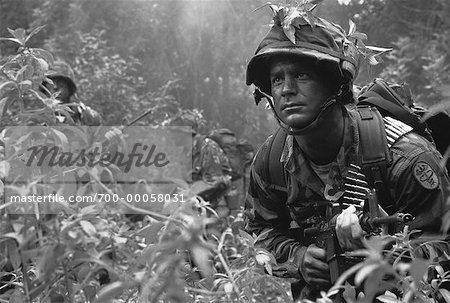 Soldiers Wearing Camouflage Carrying Weapons in Jungle