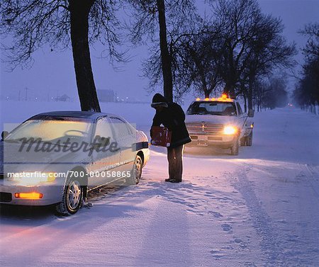 Mann, die Betankung ins Stocken geraten Auto im Winter, Ottawa, Ontario, Kanada