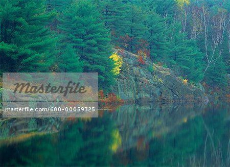 Forêt et rochers en automne avec des reflets sur le lac, près de Sudbury, Ontario, Canada