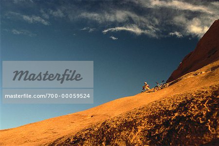 Mann, sitzend auf Hügel mit Mountain Bike, Moab, Utah, USA