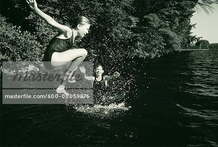 Fille en maillot de bain, sauter dans l'eau, des lacs Belgrade, Maine, États-Unis