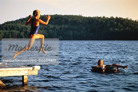 Fille en maillot de bain, sauter dans l'eau de lacs Belgrade Dock, Maine, États-Unis