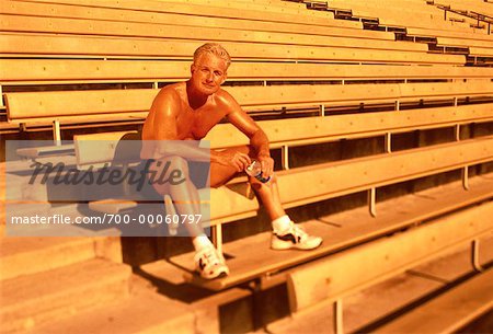 Portrait of Mature Man Sitting On Bleachers with Water Bottle