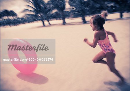 Fille en maillot de bain, chassant la chambre à air sur la plage