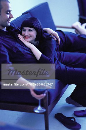 Couple Relaxing on Sofa with Glass of Wine