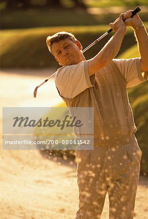 Mature Man Golfing from Sand Trap