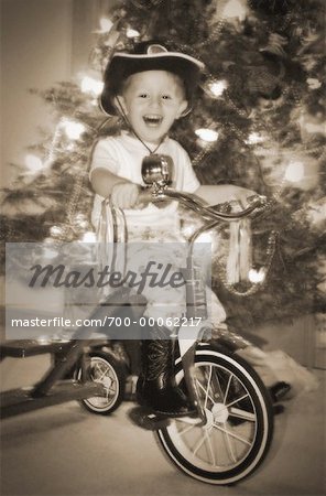 Portrait de garçon sur Tricycle devant l'arbre de Noël