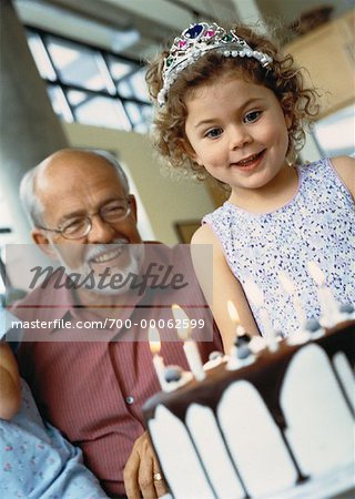 Grand-père et petite-fille de gâteau d'anniversaire en regardant sur la Table