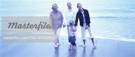 Portrait of Four Generations of Women Standing in Surf on Beach