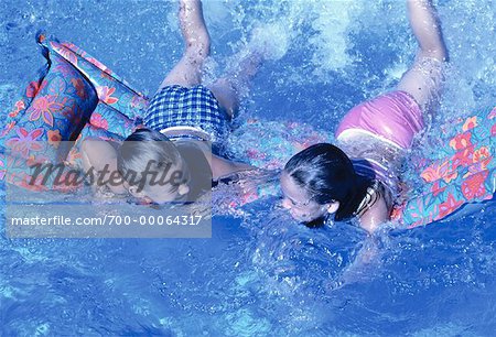 Two Girls on Floatation Device In Swimming Pool