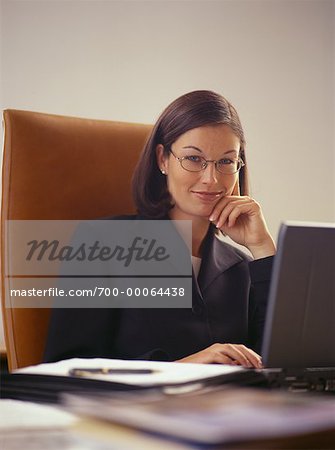 Portrait de femme d'affaires assis au bureau avec ordinateur portable