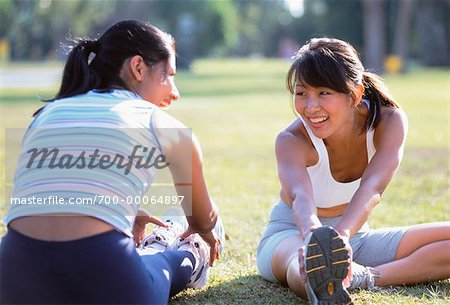 Two Women Sitting Outdoors Stretching