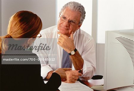 Business People Sitting in Office Talking in Front of Computer