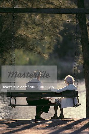 Vue arrière du Couple d'âge mûr sur Swing dans le parc, Miami, FL, Etats-Unis