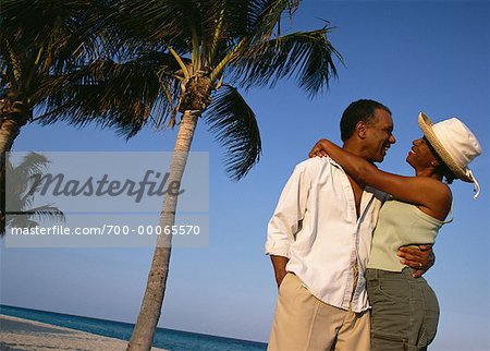 Mature Couple embrassant près de palmiers