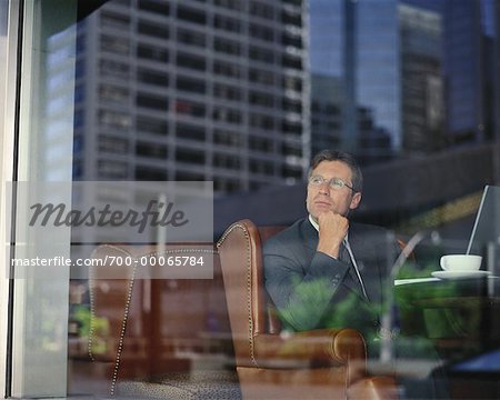 View of Businessman at Table in Restaurant through Window