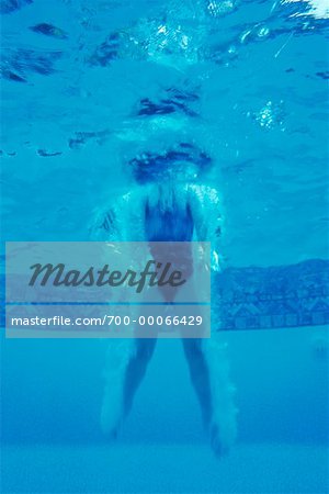 Vue sous-marine de fille sautant dans une piscine