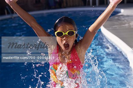 Girl in Swimwear and Goggles Jumping in Swimming Pool