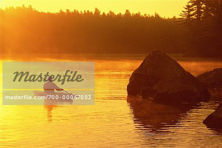 Man Kayaking at Sunset Belgrade Lakes, Maine, USA