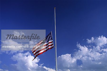 American Flag at Half Mast with Clouds in Sky