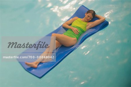 Femme en maillot de bain, allongé sur le matelas de mousse dans la piscine
