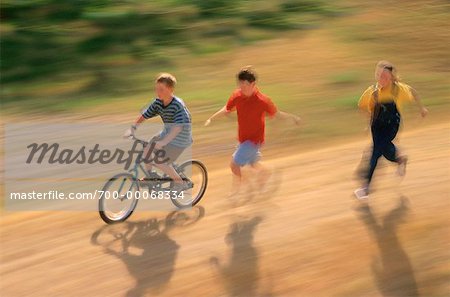 Kinder laufen nach junge auf Fahrrad