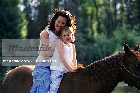 Portrait de la mère et la fille assise sur le cheval