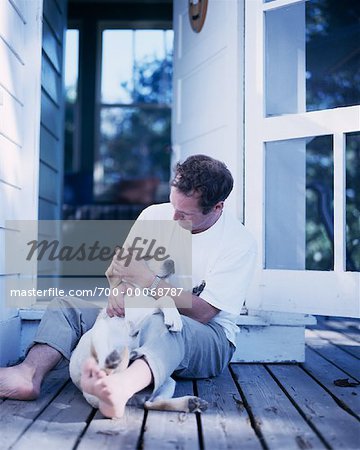 Mann sitzt auf dem Deck mit Hund Bala, Ontario, Kanada