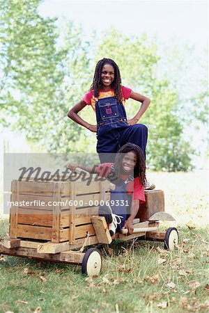 Portrait of Two Girls with Soapbox Car Outdoors
