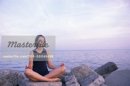 Femme assise sur les rochers de pratiquer le Yoga, Toronto, Ontario, Canada