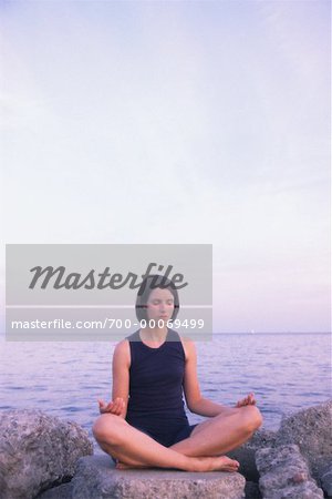 Femme assise sur les rochers de pratiquer le Yoga, Toronto, Ontario, Canada