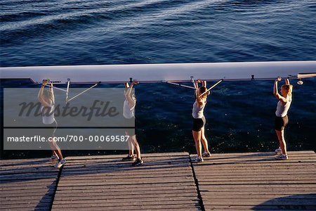 Female Rowers Carrying Boat on Dock