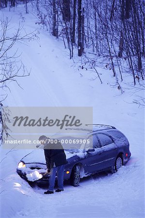 Mature Man pelleter la neige en face de la voiture