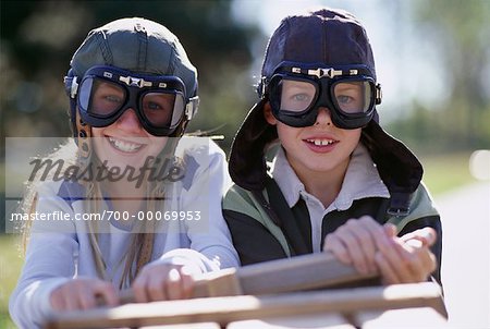 Porträt der jungen und Mädchen, die das Tragen von Schutzbrillen, sitzend in Seifenkiste Auto