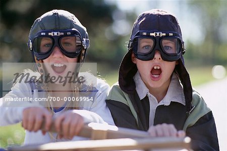 Portrait of Boy and Girl Wearing Goggles, Sitting in Soapbox Car