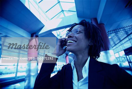 Businesswoman Using Cell Phone Laughing in Terminal