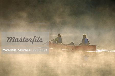 Couple de canotage sur le lac avec brouillard, Haliburton, Ontario, Canada