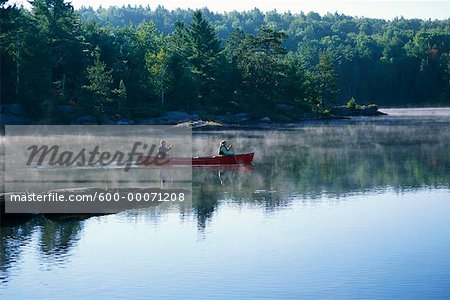 Couple Canoeing on Lake, Haliburton, Ontario, Canada