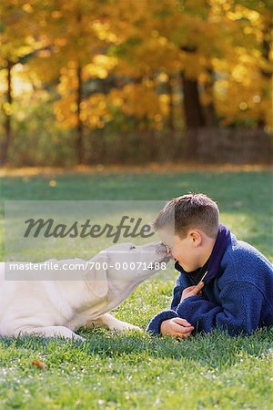 Garçon et chien couché dans le champ à l'automne