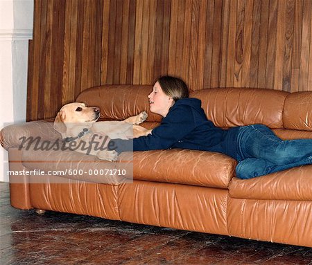 Adolescente, allongé sur le canapé avec chien