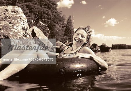 Portrait of Woman in Swimwear in Inner Tube on Lake, Smiling Belgrade Lakes, Maine, USA